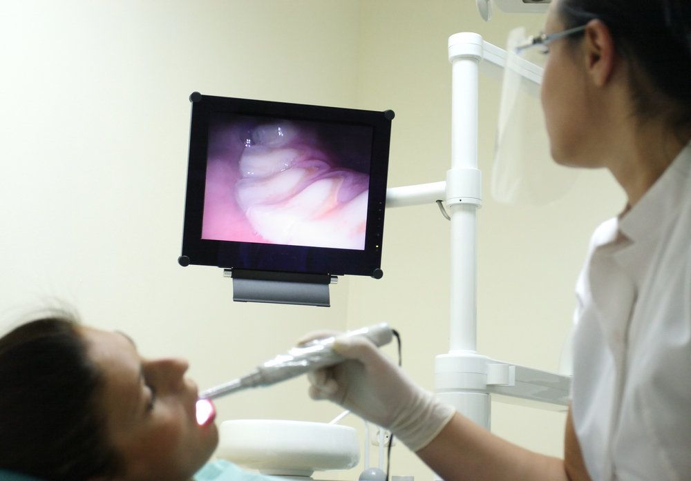 <p>A dentist holding an intraoral camera within a patient&#39;s mouth.</p>
